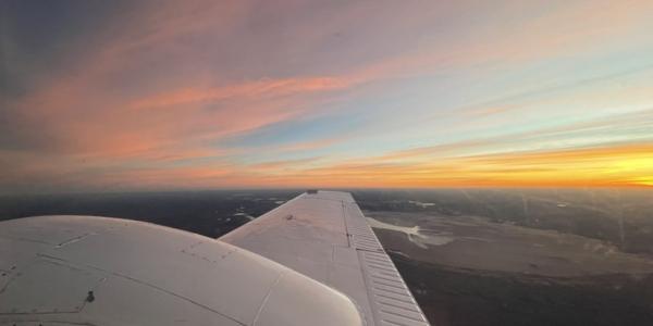 view of sunset from wing window of plane